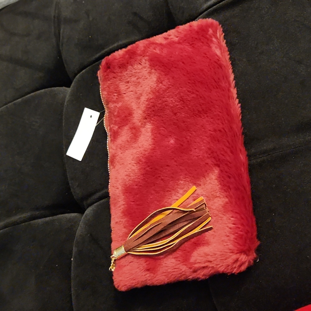 Burgundy clutch or wear has a shoulder. Gold strap included..